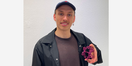 Portrait of Yannic Malte Müller with a 3D printed model of the host-guest system which was studied by him during his Bachelor thesis